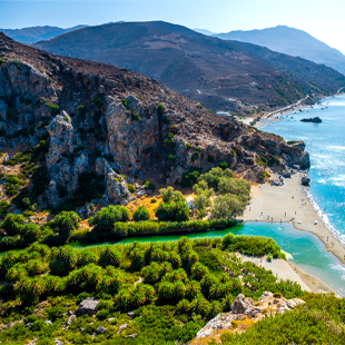 De groene palmbomen en rivier monden uit in de zee bij Preveli